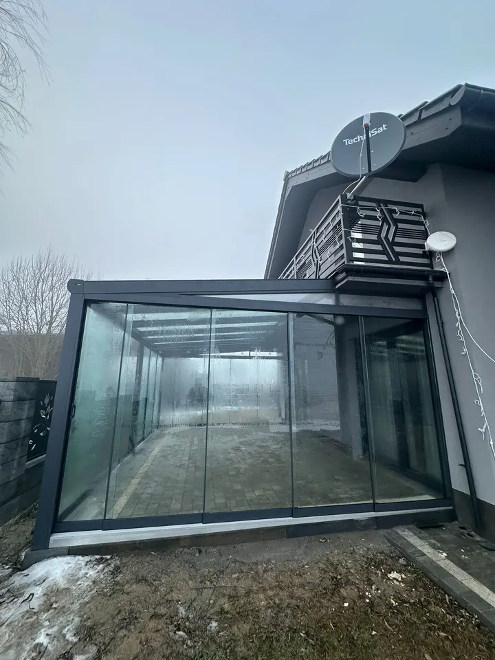Gotowa szklana zabudowa tarasu pod balkonem w Świerklanach, widok zimą z zaparowanymi szybami