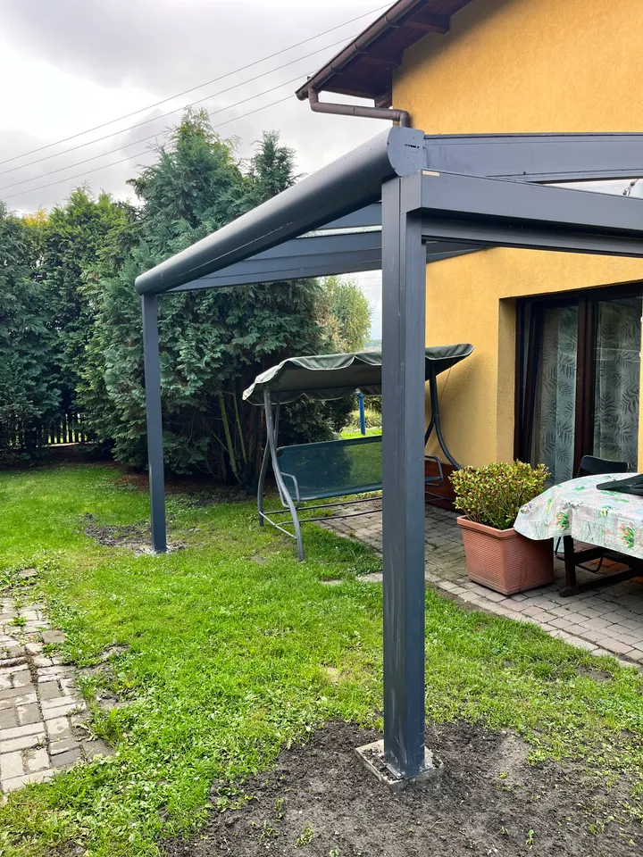 Szklane zadaszenie tarasu przy żółtym domu w Rydułtowach, widok z narożnika ogrodu