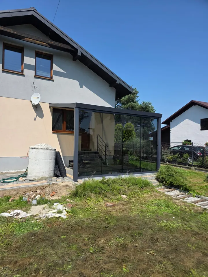 Grafitowa zabudowa ze szklanym frontem przy wejściu do domu w Pawłowicach