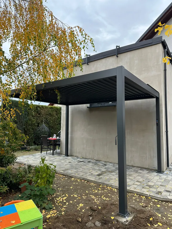 Antracytowa pergola lamelowa przy domu w Suszcu, widok od strony ogrodu